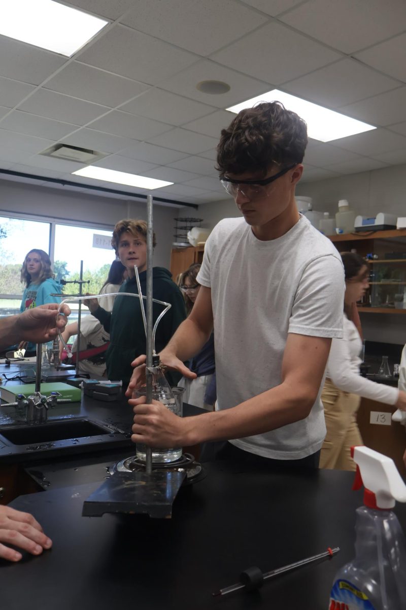 Setting up the beaker, sophomore Grant Hunault participates in the chemistry lab. On Oct. 7, chemistry teacher Chuck Miller's fifth hour class measured pressure through temperature. 