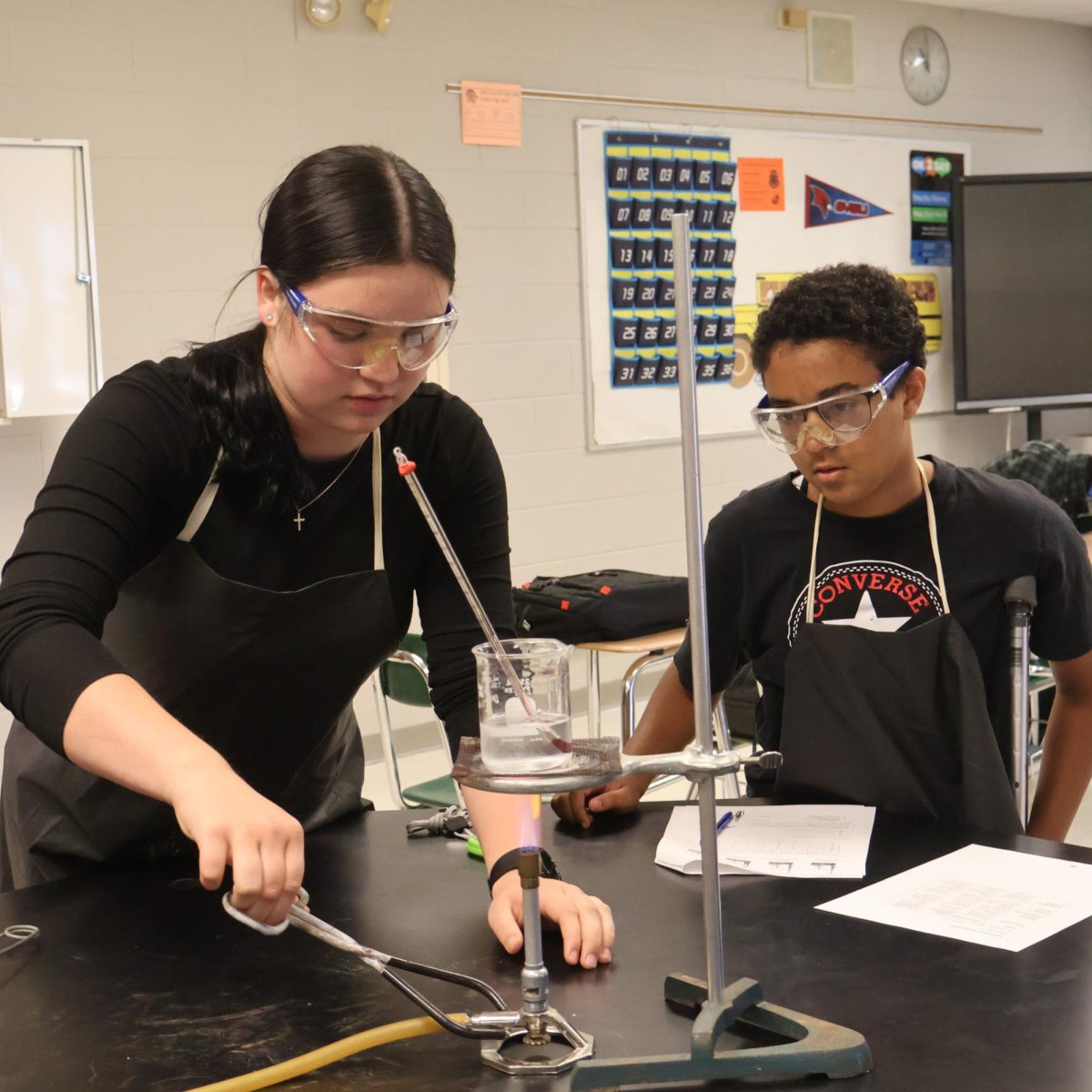 Concentrating, sophomore Lilie Blough and Eva Douglas participate in a chemistry lab. On Oct. 8th, Mr. Sturms 3rd hour class prepared to heat water.