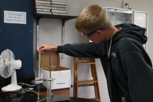 Focusing, sophomore Aaden Gilbert measures the temperature of the water. On Oct. 8, Sturm's chemistry class held a bunsen burner lab. 