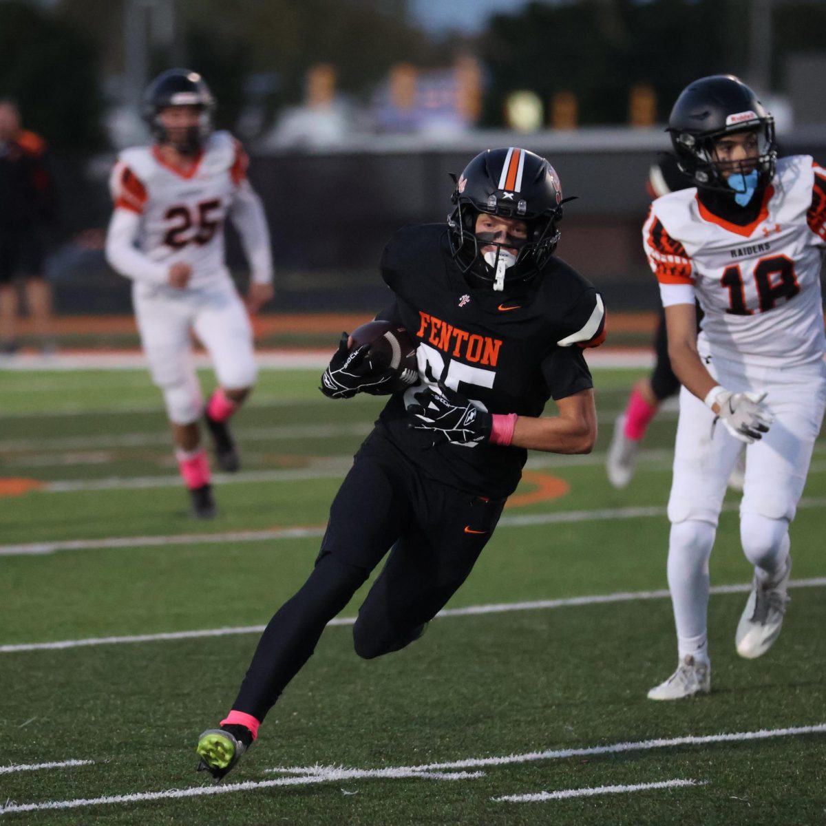 Sprinting, sophomore Dakota Lawrence runs down the sideline with the ball looking to score. On Oct. 10, The Fenton JV Tigers beat Flushing 35-7.