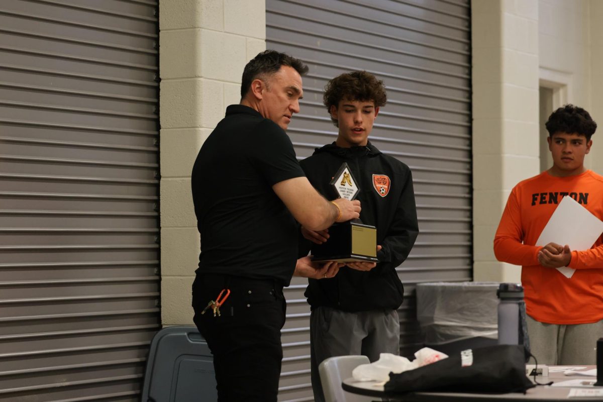 Grabbing his trophy, junior Dillon Hamilton gets awarded the golden shoe trophy. On Oct. 25, the boys soccer team held a banquet to celebrate their season and acknowledge players. 