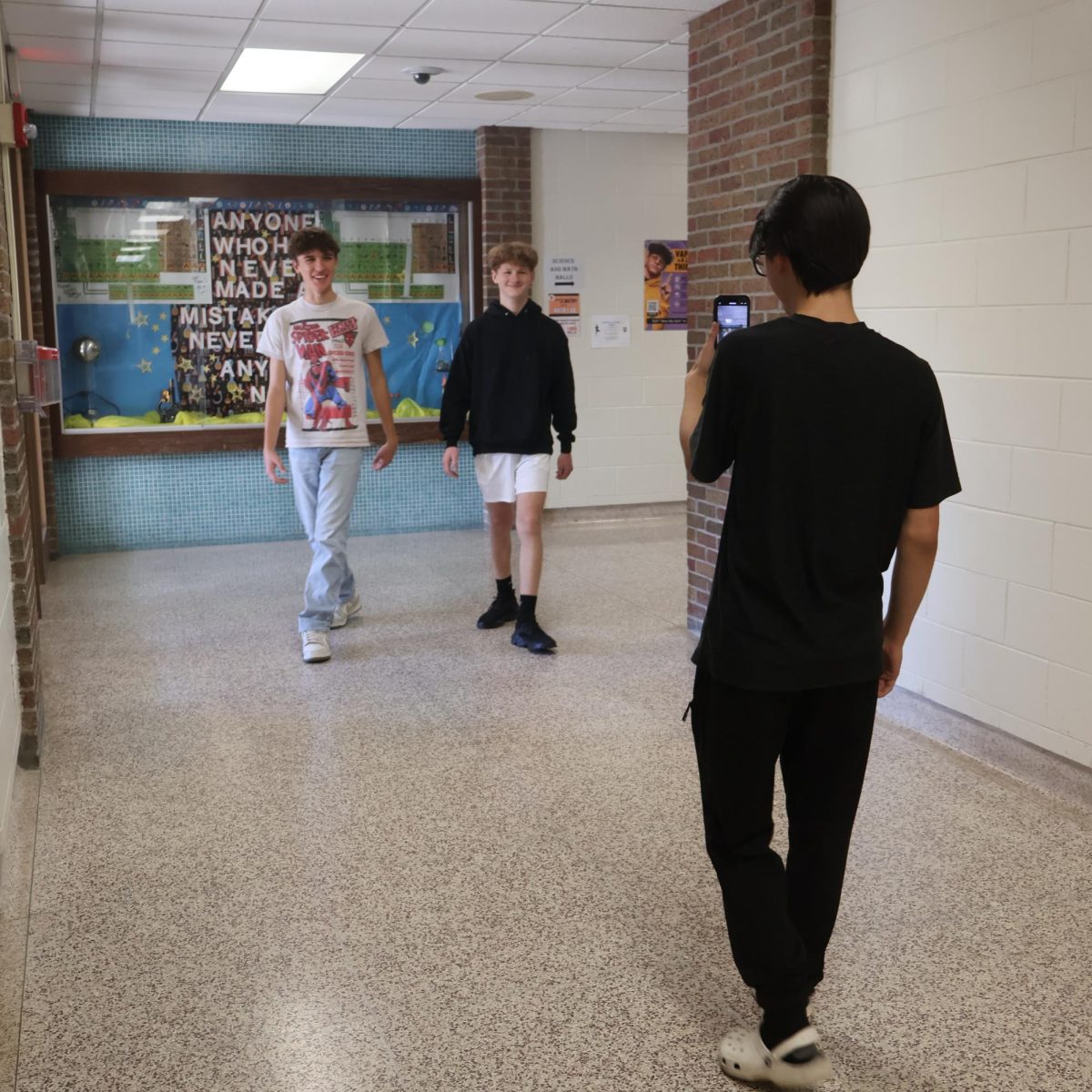 Smiling, sophomore Gentry Watson walks alongside his classmate. On Oct. 21, the ELA classes filmed their video project.