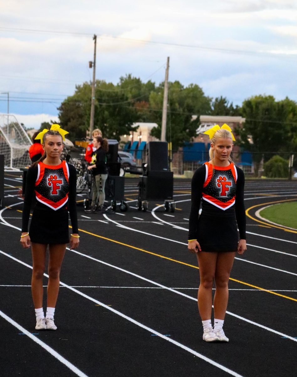 Waiting, sophomore Lillian Brawner prepares to do a flip. On Sept. 6, Fenton varsity cheer performed in front of the student section at the Light Up the Night varsity football game. 