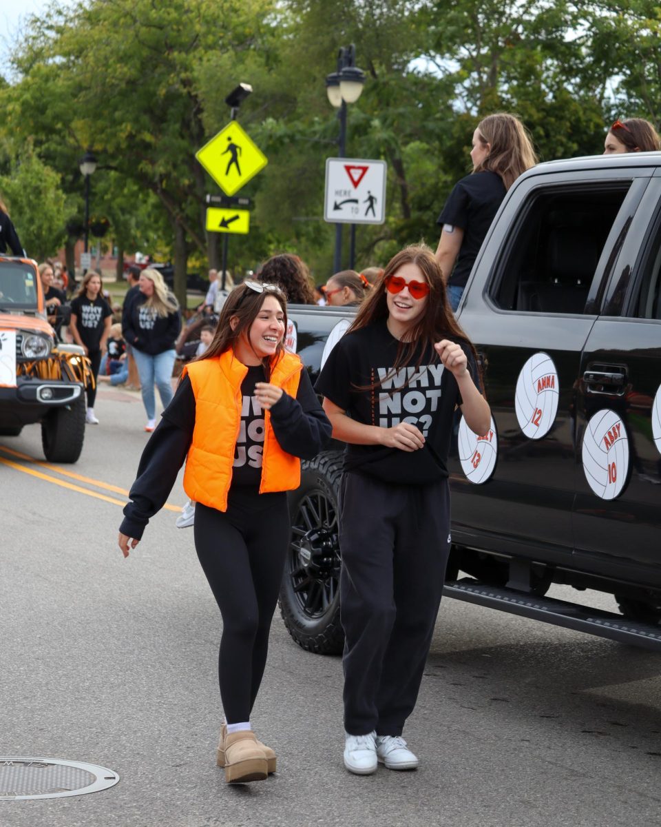 Walking, sophomores Alexis Roberts and Alexis Stone show support for the Fenton varsity volleyball team. On Sept. 27, Fenton High kicked off their homecoming with a parade through the town.