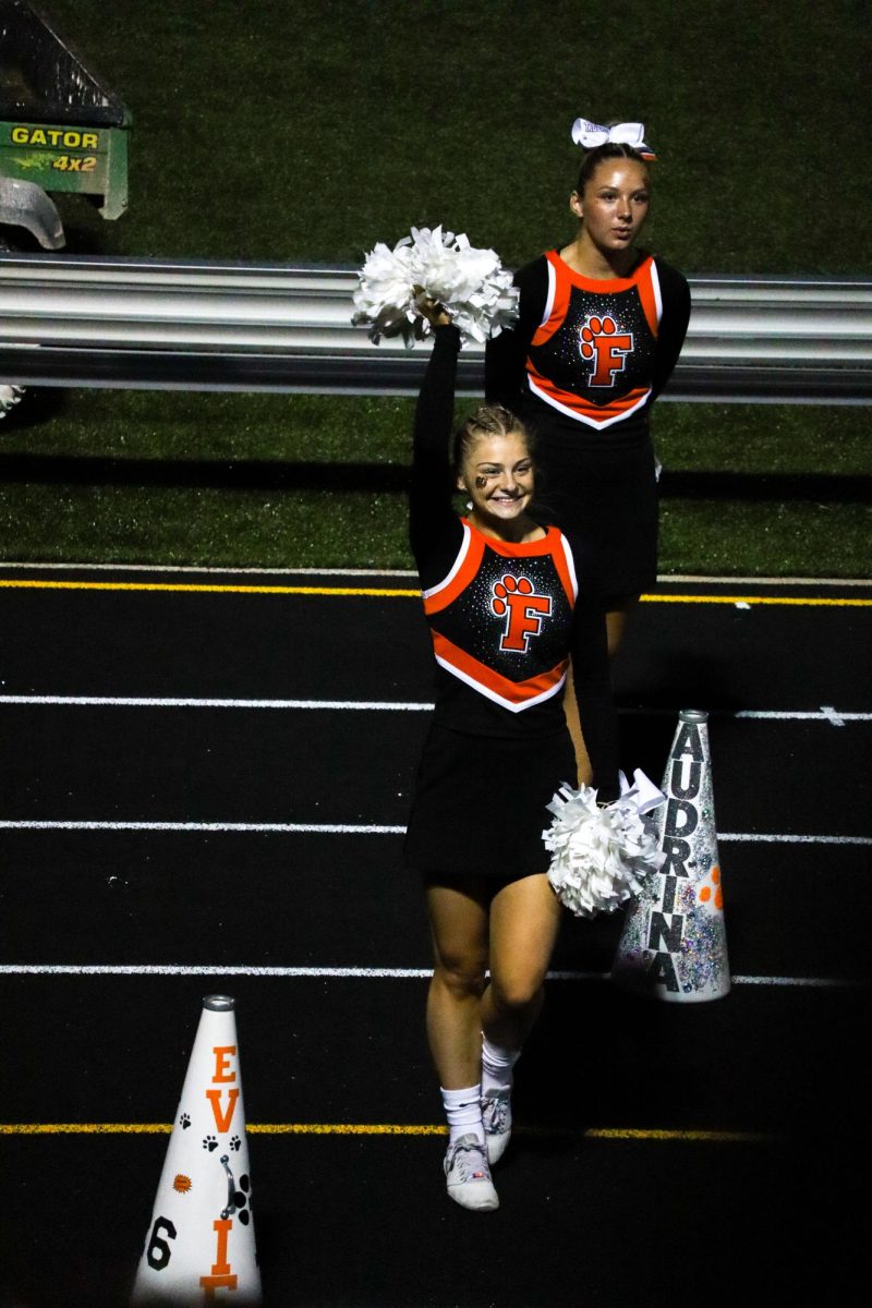 Waving, junior Evie Metcalf is announced at the varsity homecoming game. On Sept. 27, Fenton varsity football played against Kersley. 