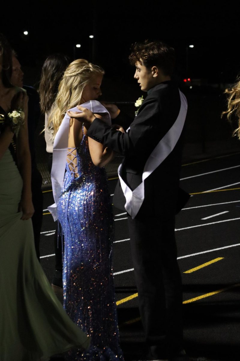 Preparing, freshman Lucy Britton wears her homecoming sash. On Sept. 27, Fenton High announced their 2024 homecoming court and representatives at half time.  