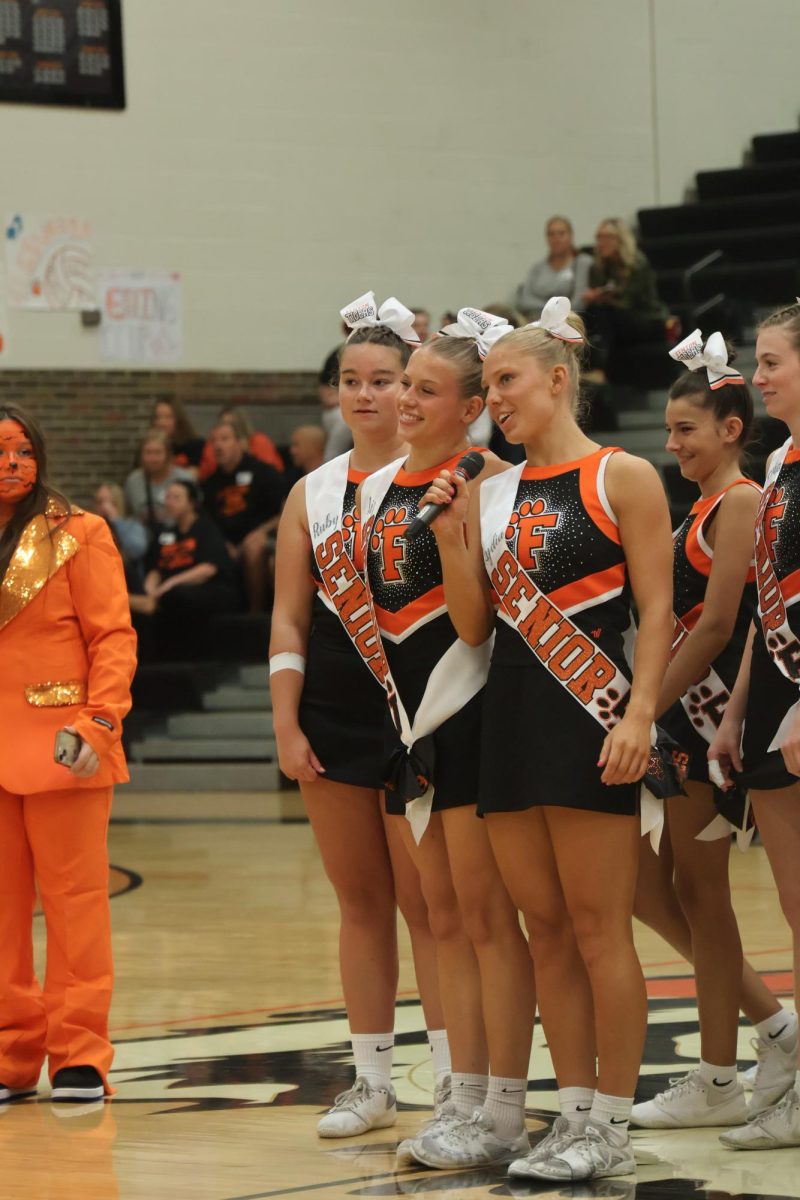 Talking to the crowd, seniors Liz Beaven and Lydia Klemish introduce the FHS cheer team. On Sept. 27, the annual homecoming pep rally took place in the gym. 