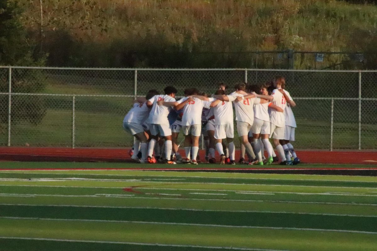 Cheering, the FHS varsity soccer team wrap their arms around each other and jump. On Sept. 25 the boys team competed against Linden winning 4-3.