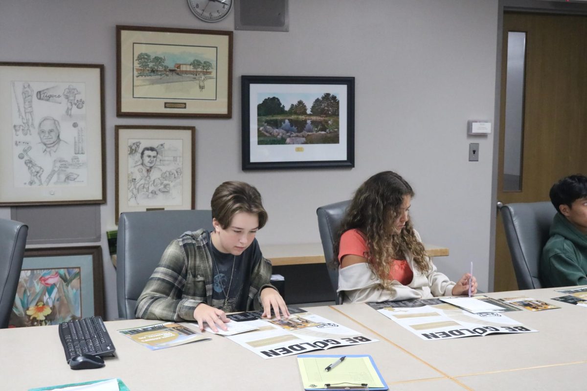 Reading, sophomore Elliot Green reviews information at the Oakland University college visit. On Oct. 3, supervisors from Oakland University came to inform Fenton students about important college information.
