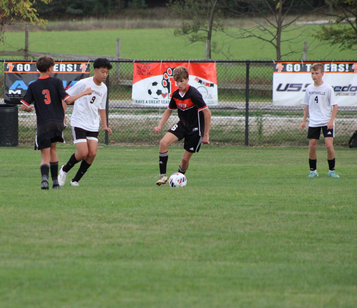 Dribbling the ball, sophomore Lewis Roberts keeps the ball from his defender. On Sept. 30, the JV soccer team played Northville losing 1-2.