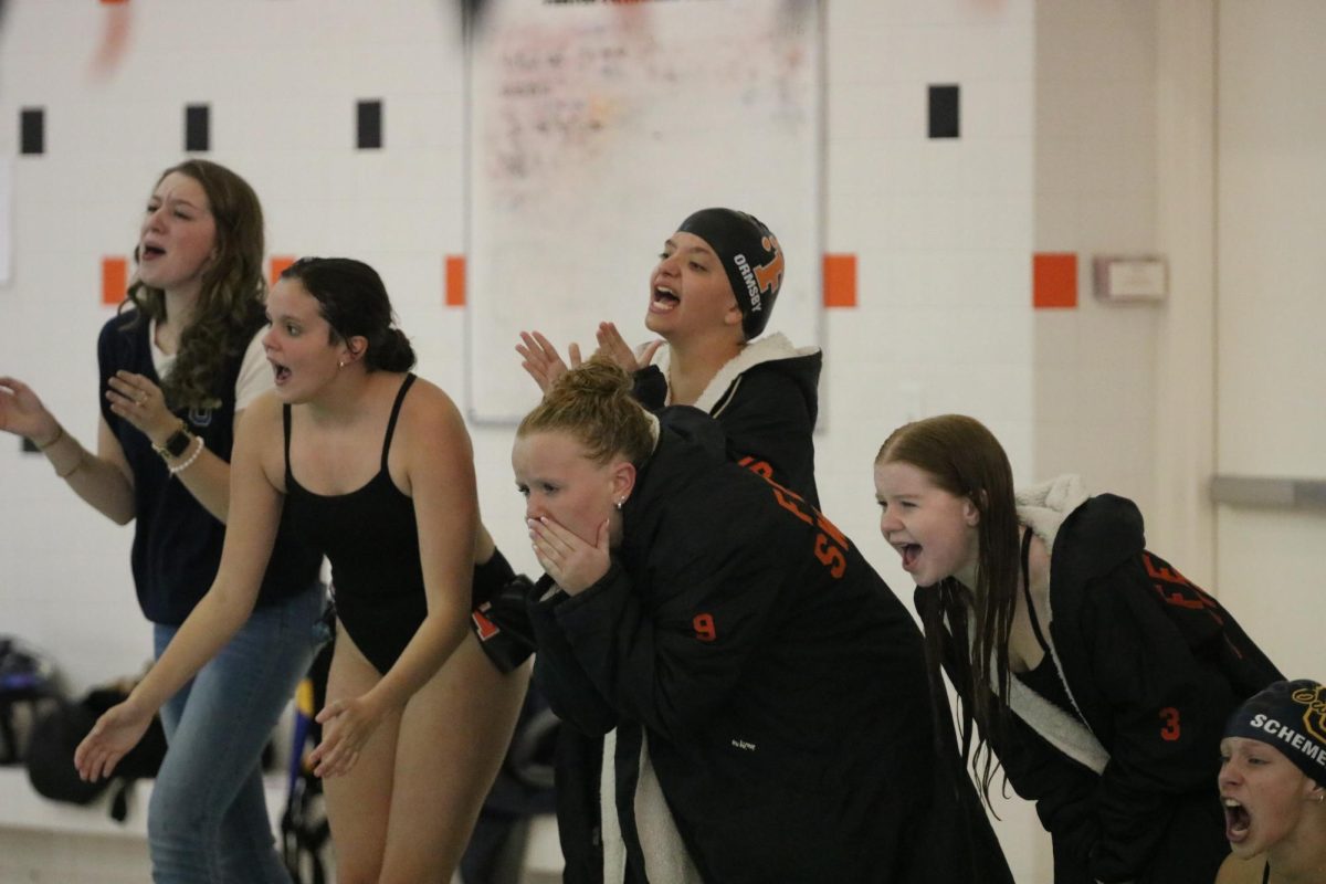 Cheering, the Swim and Dive team screams and cheers for their team. On Oct. 17, The Fenton Swim and Dive team won their meet against Owasso 111-75.