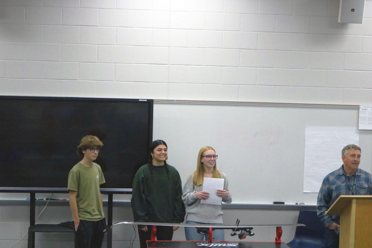 Speaking, senior captains Anna Heimberger and Emersyn Sprague stand alongside junior captain Kolton Sprague as they inform underclassman about the Fenton Linden Lake Fenton ski team. On Oct. 14 the ski team hosted an informational meeting about the upcoming ski season. 