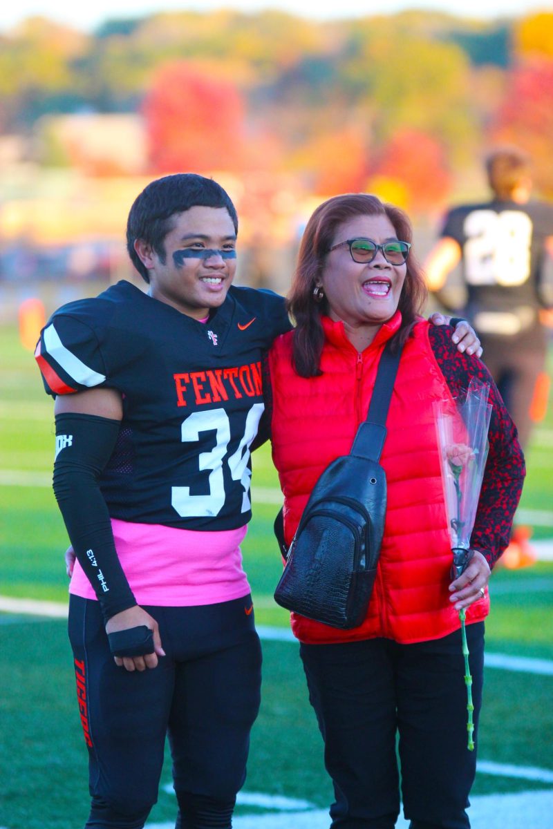 Smiling, senior Mario Anthony Yap, celebrates with his mother. On Oct. 20, Senior Night is held at Fenton High Schools football field. 