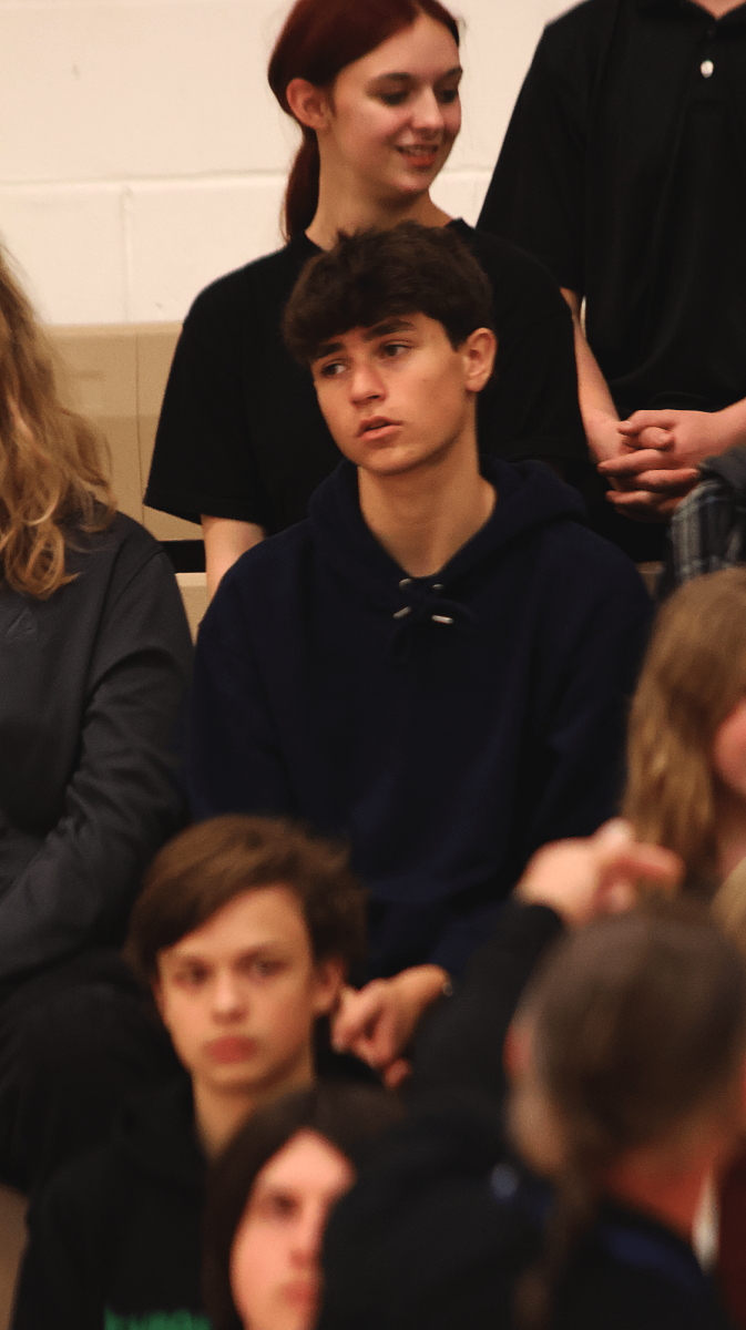 Sitting, sophomore Jackson Defina waits to be photographed. On Nov. 14, clubs gathered in the AUX gym to be photographed for the yearbook.  