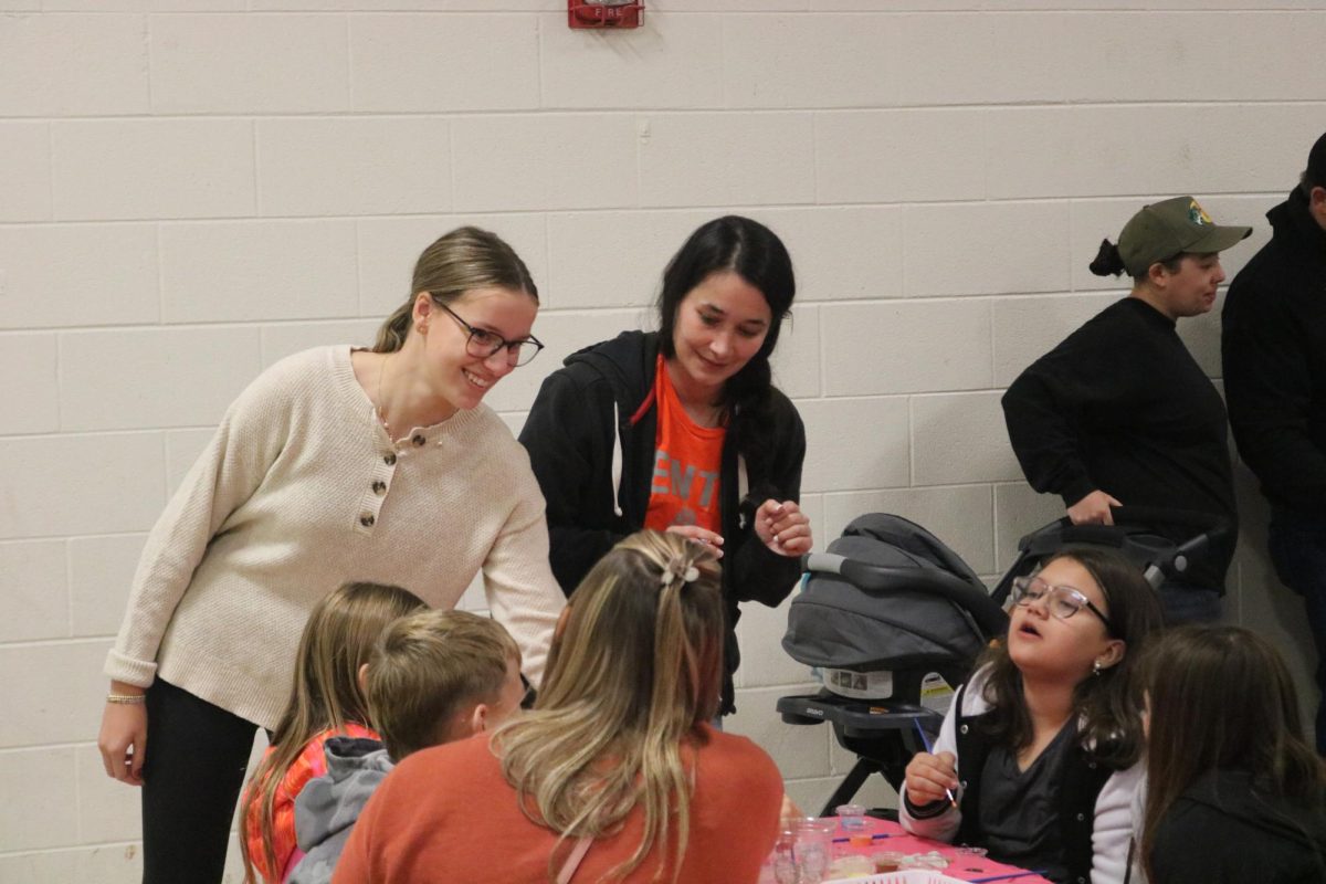 Smiling, junior Emily Kaplan cleans up a table. On Nov. 20 National Honors Society students helped kids with ornament painting at Tomek-Eastern Elementary. 