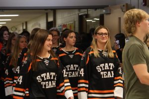 Smiling, senior Addison Dolliver and Tess Heavner participate in the swim state qualifying walk out. On Nov. 21, the girls swim teams state qualifiers had a walk out to celebrate their accomplishments.