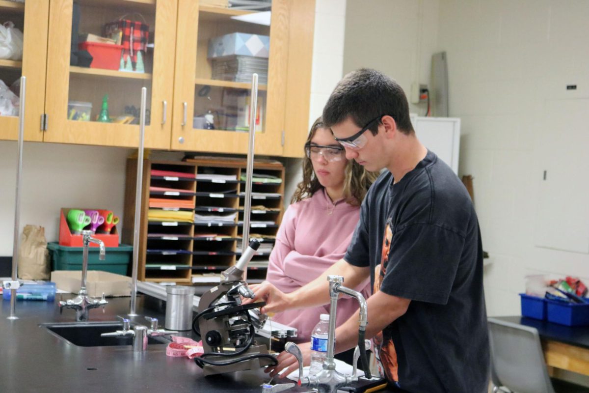 Adjusting the telescope, junior Luke Dotson and sophomore Gaia Watson prepare for their lab. On Oct. 31, students in physics experimented with velocity. 