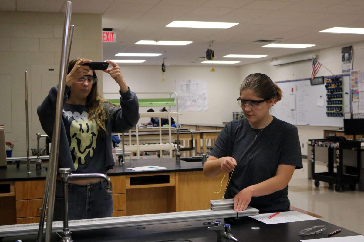 Launching the ball seniors Emma Rush and Aubrey Lehman participates in their physics lab.  On Oct. 30, Aubrey aims to shoot the ball in the cup to see the reaction of velocity. 