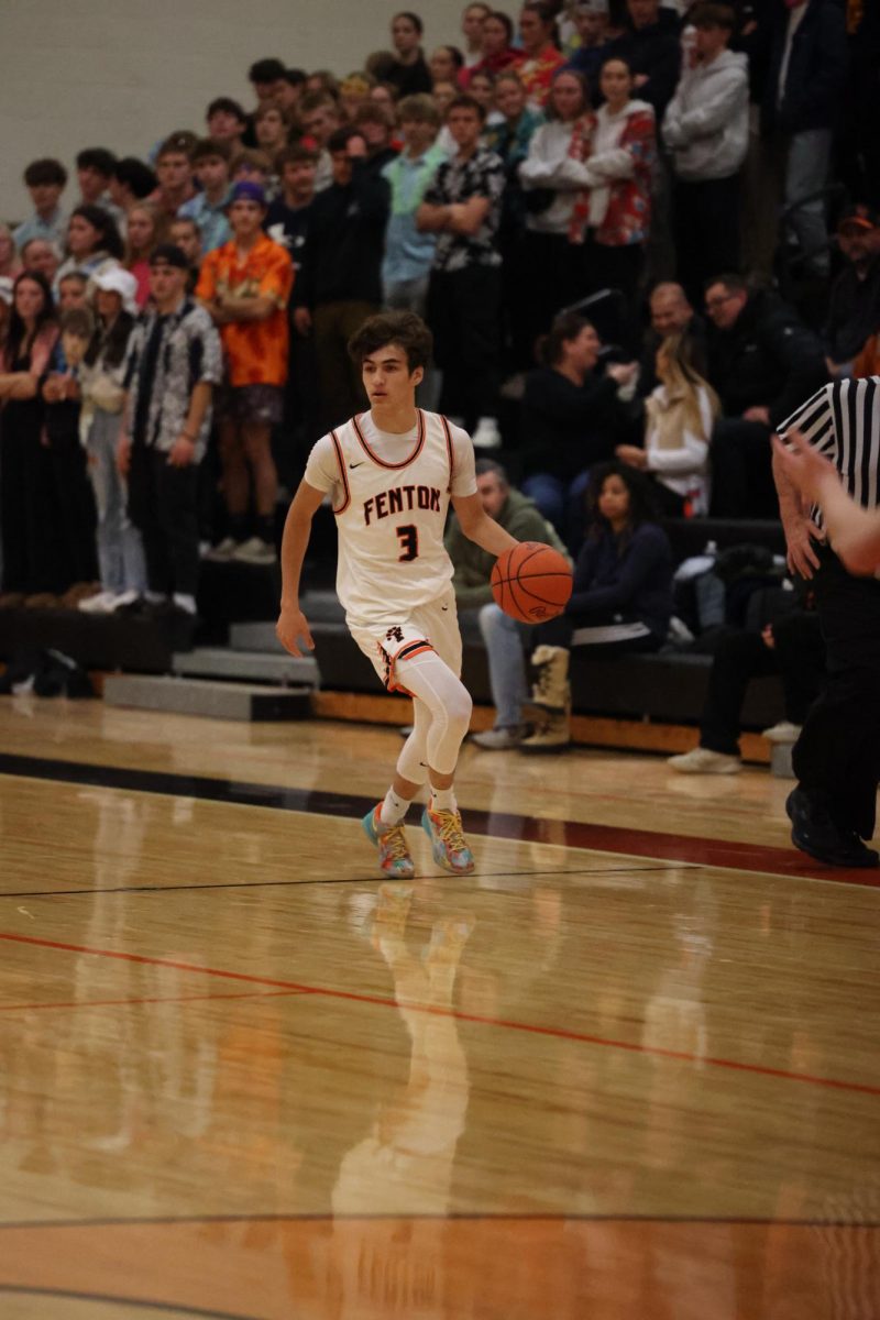 Looking up the court, senior Gavin Yanez dribbles the ball. On Dec. 6, the boys varsity team took on the Swartz Creek dragons and lost 55-66.