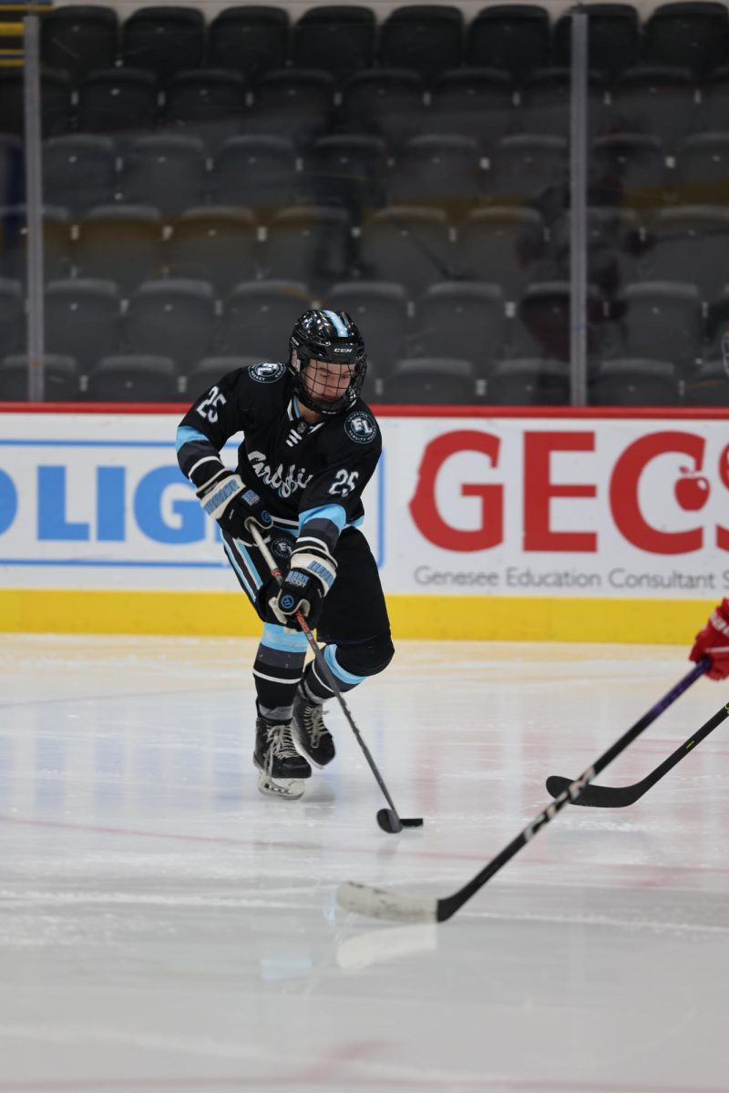 Handling the puck, junior Mason Wright skates down the ice to the goal. On Dec. 11, the Griffins lost to the Genesee Generals.