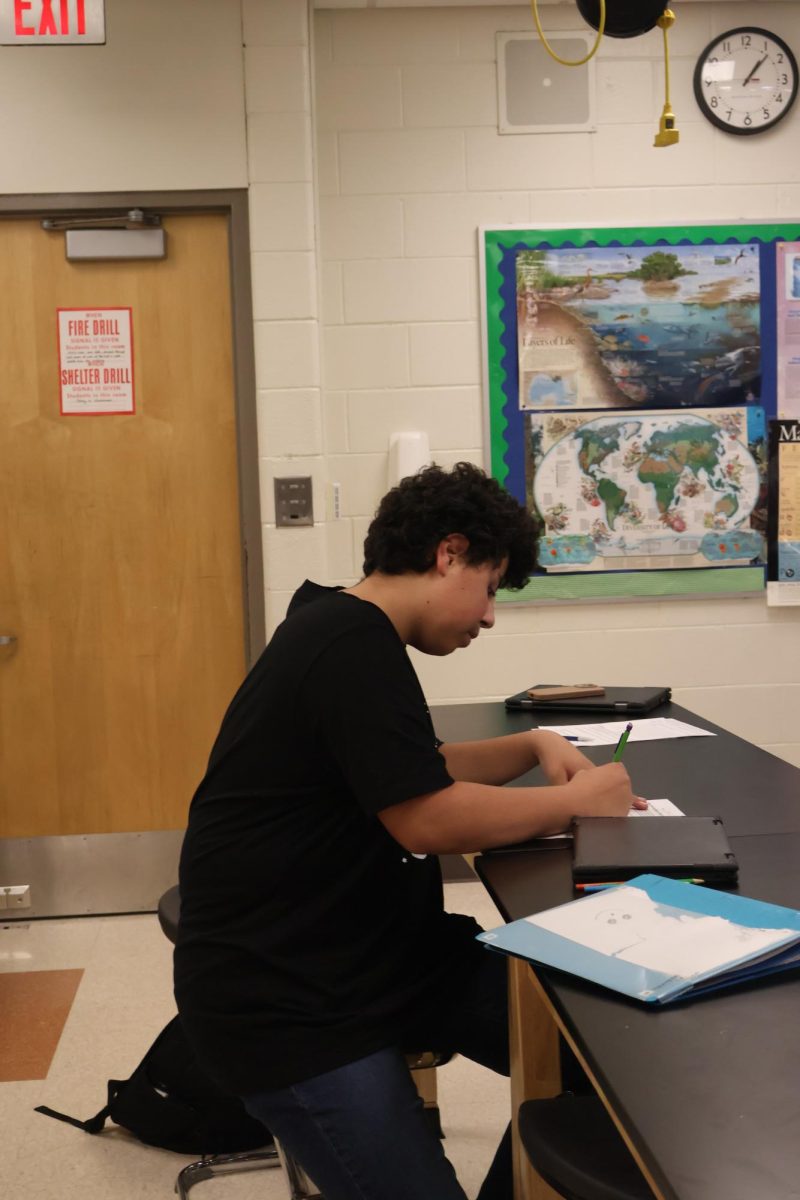 Writing, freshman Jabin Sachenko works on his biology assignment. On Dec 9, Nicholas Jeffery's taught his class about the heart and how it works.