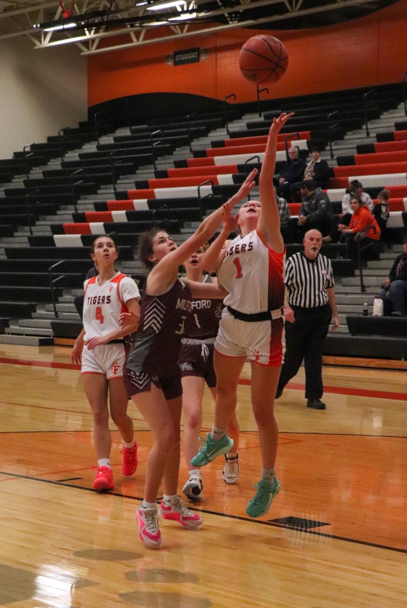 Attempting a shot, sophomore Payton Roney tries to score in a recent game. On Dec. 10, the girls JV basketball team played Milford and won.