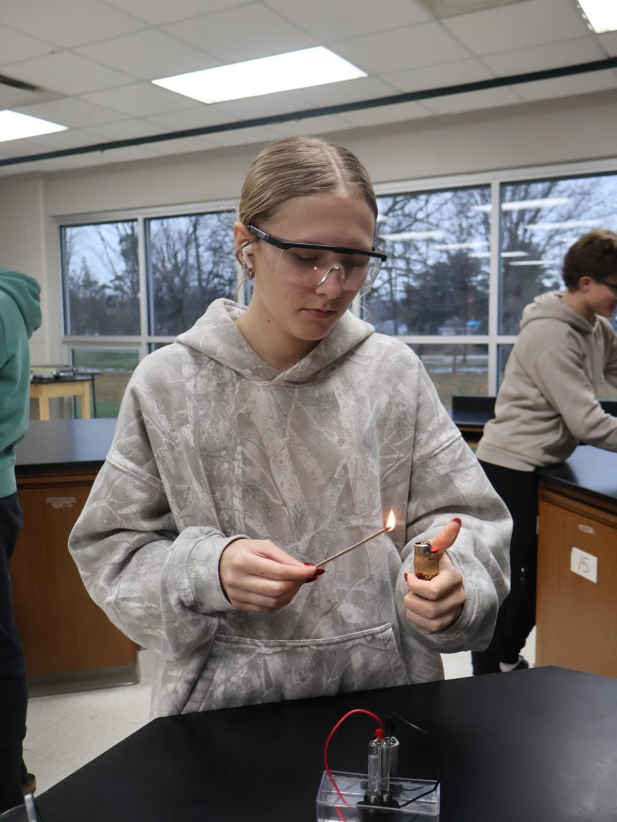 Focusing, sophomore Addie Coleman uses a lighter to light a stick on fire. On Dec. 4, the 5th hour chemistry class participated in a lab