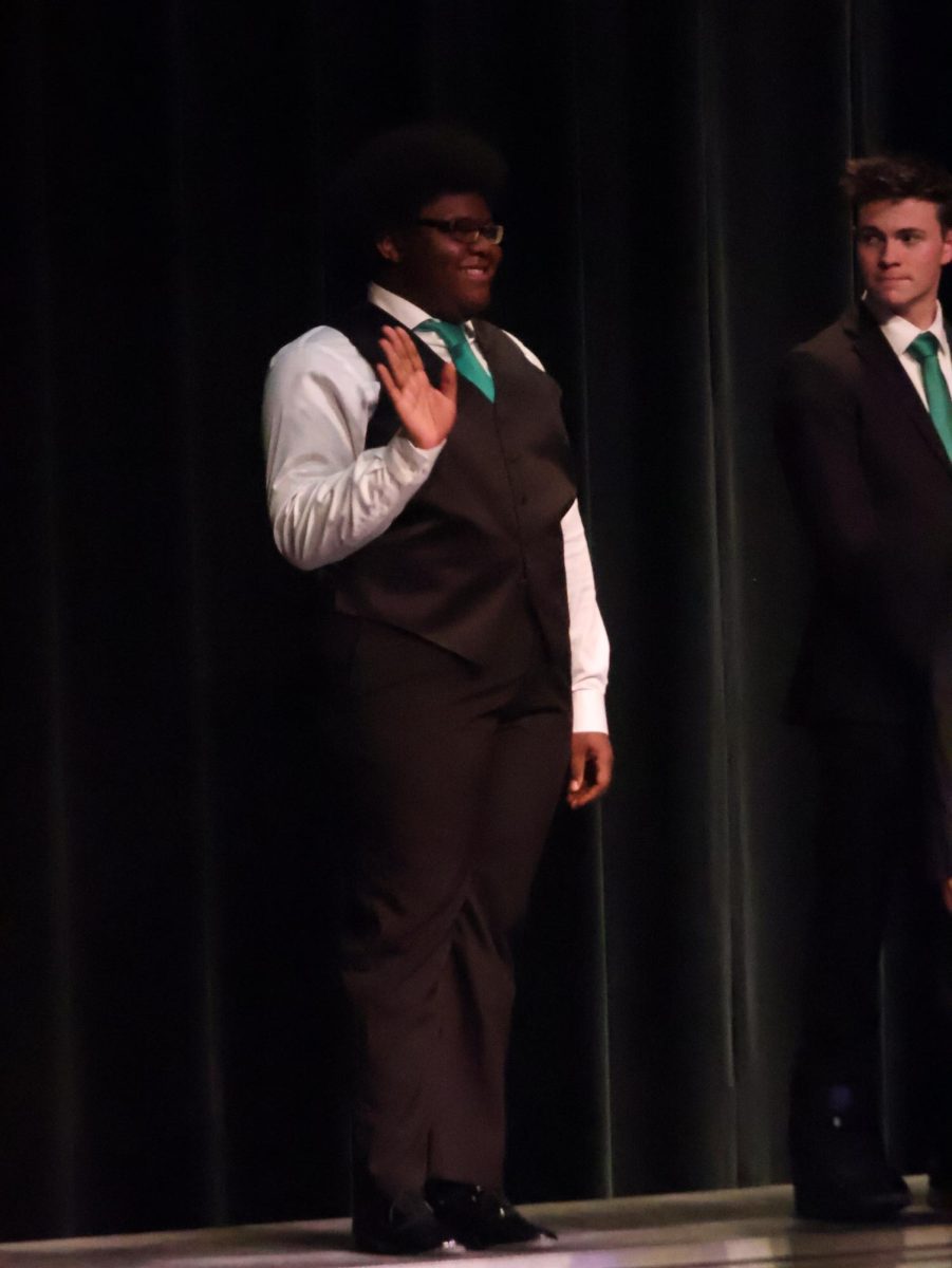 Waving, senior Donnell Hall rehearses for ambassadors. On Dec. 6, Mr. Wright held a rehearsal in the auditorium for their upcoming concert on Dec. 12.