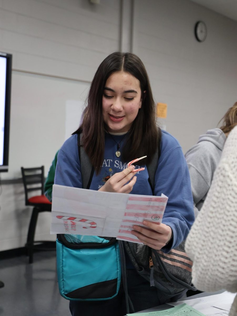 Reading, sophomore Janessa Bemman looks at letters to santa from kids. On Dec. 10, the Key Club members chose a letter to respond to.