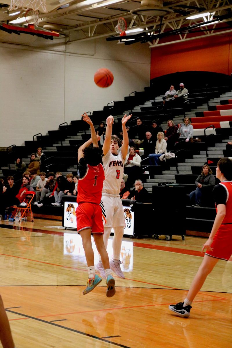 Shooting, sophomore Spencer Irwin puts up a three pointer. On Dec. 12, the Fenton JV basketball team went up against Holly and won