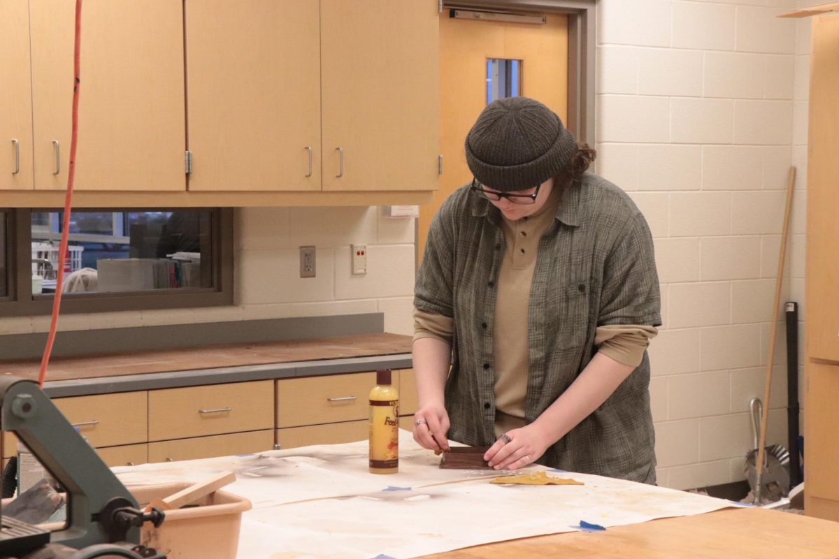 Gluing, junior Sophia Tottingham makes her final touches on her woodwork project. On Dec. 11, the woodshop class created presents for christmas. 