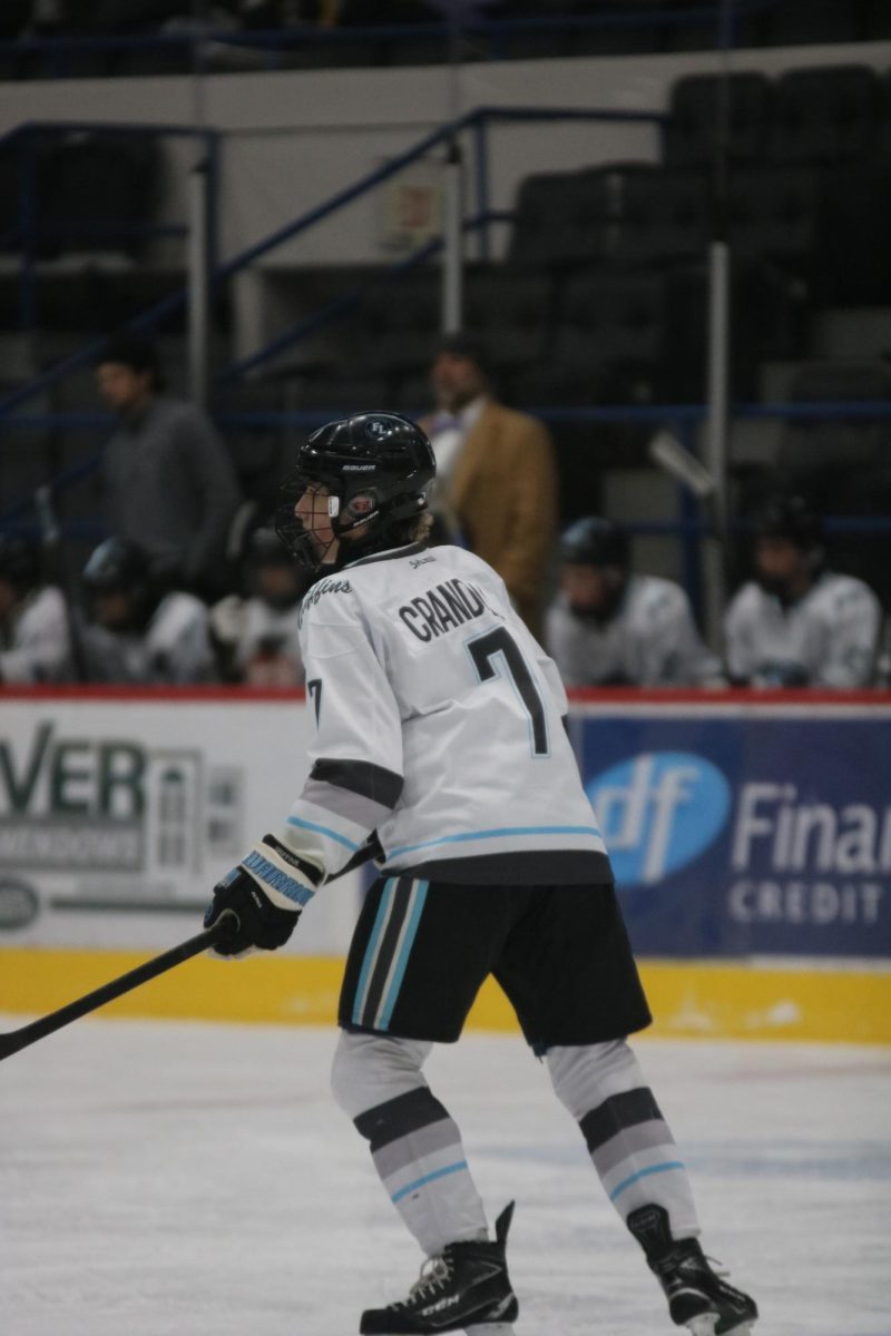 Skating, senior Brennan Crandall goes towards the puck. On Nov. 29, the Griffins played Powers.