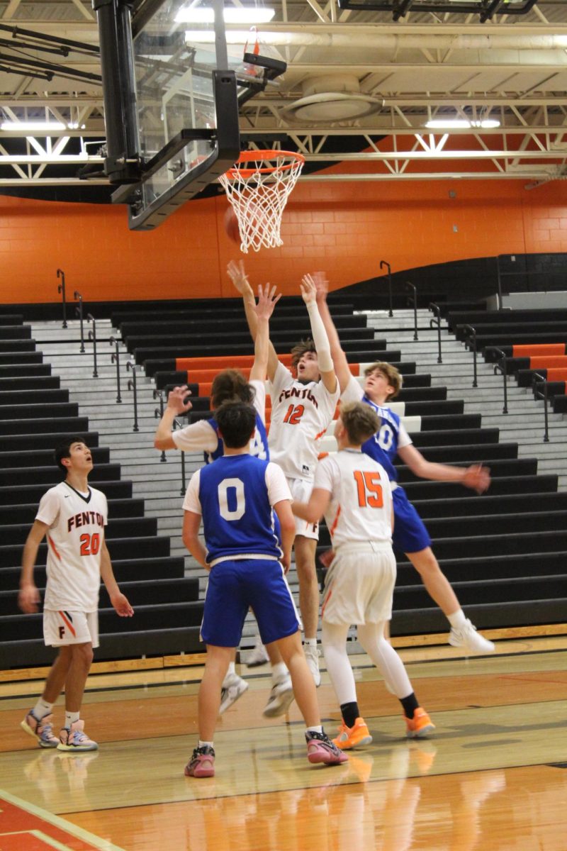 Jumping, freshman Deton Thommen shoots the ball while being heavily covered. On Dec. 3 the Boys Freshman basketball team won against Brandon 50-41.