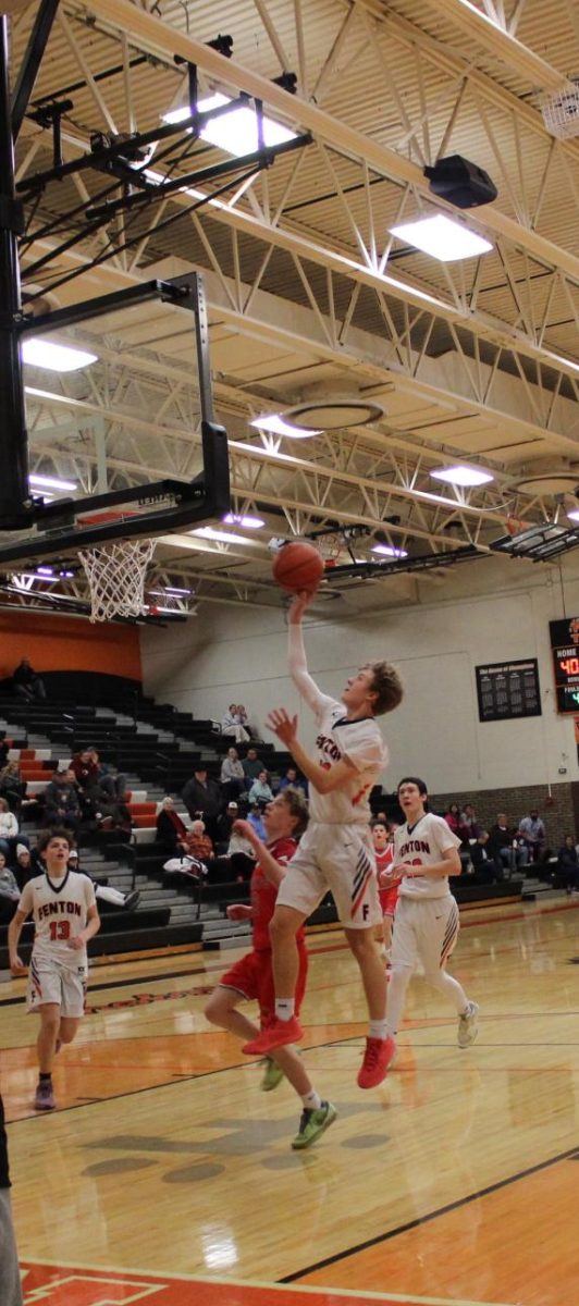 Jumping, freshman Gibson Reynolds shoots the ball. On dec.12 Fentons freshman basketball team lost to Holly 42-52