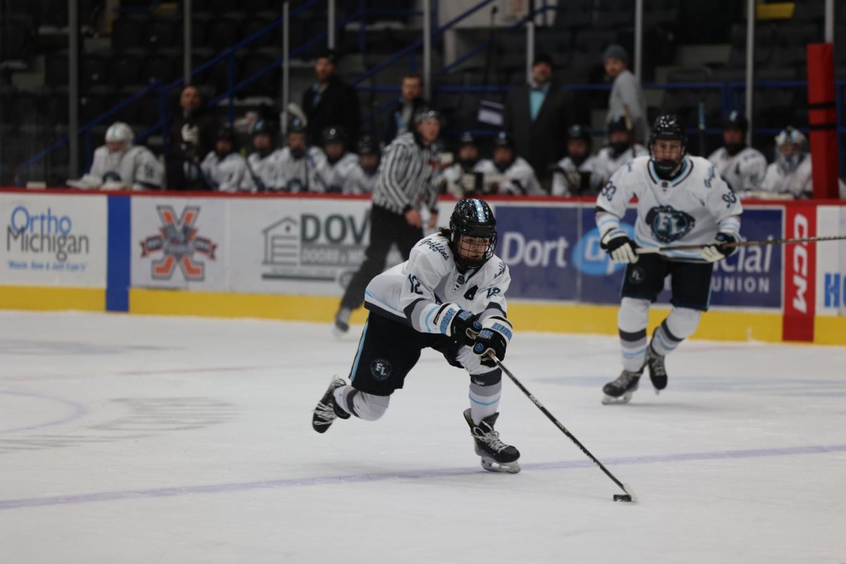 Skating, senior Dominic Corso takes the puck up the ice. On Jan. 8, the Griffins played Tri-valley and lost 3-5.