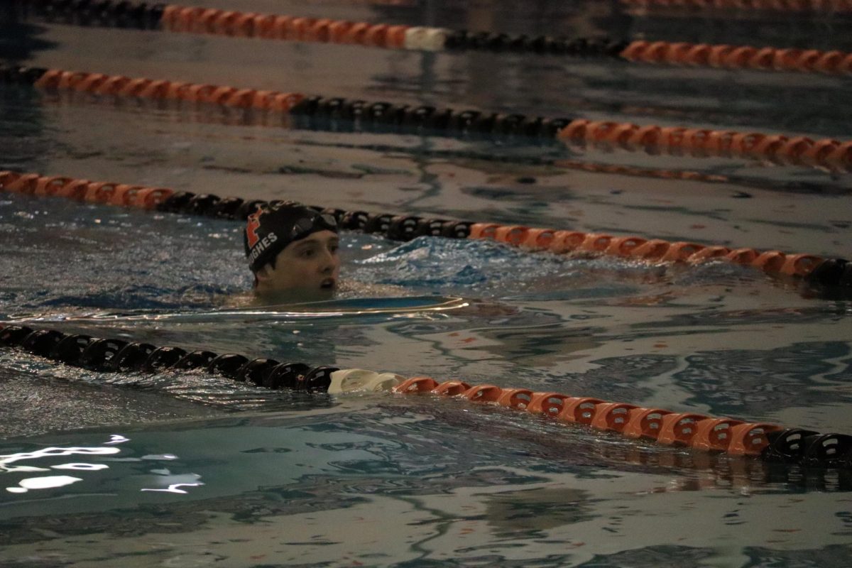 Swimming, junior Finley Hughes finishes his set. On Jan. 7, the FHS boys varsity swim team competed against Flushing. 