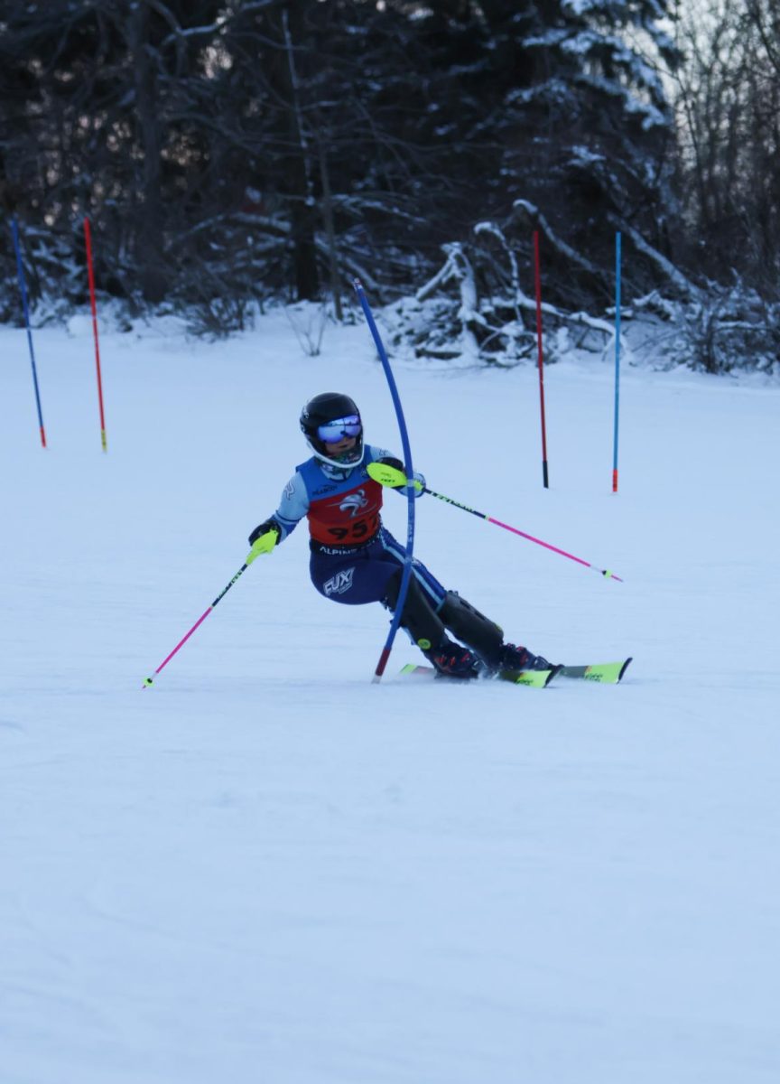 Hitting the gate, sophomore Mady Flack races down the hill. On Jan. 8, the Alpine Ski team competed against Powers with girls taking first.