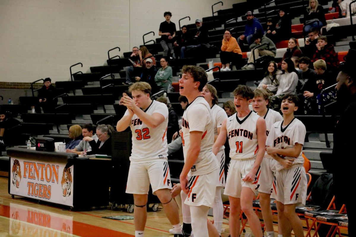 Celebrating, sophomore Madden Taylor cheers on his teammates. On Jan. 28, the Fenton JV basketball team went up against Clio winning 62-18.