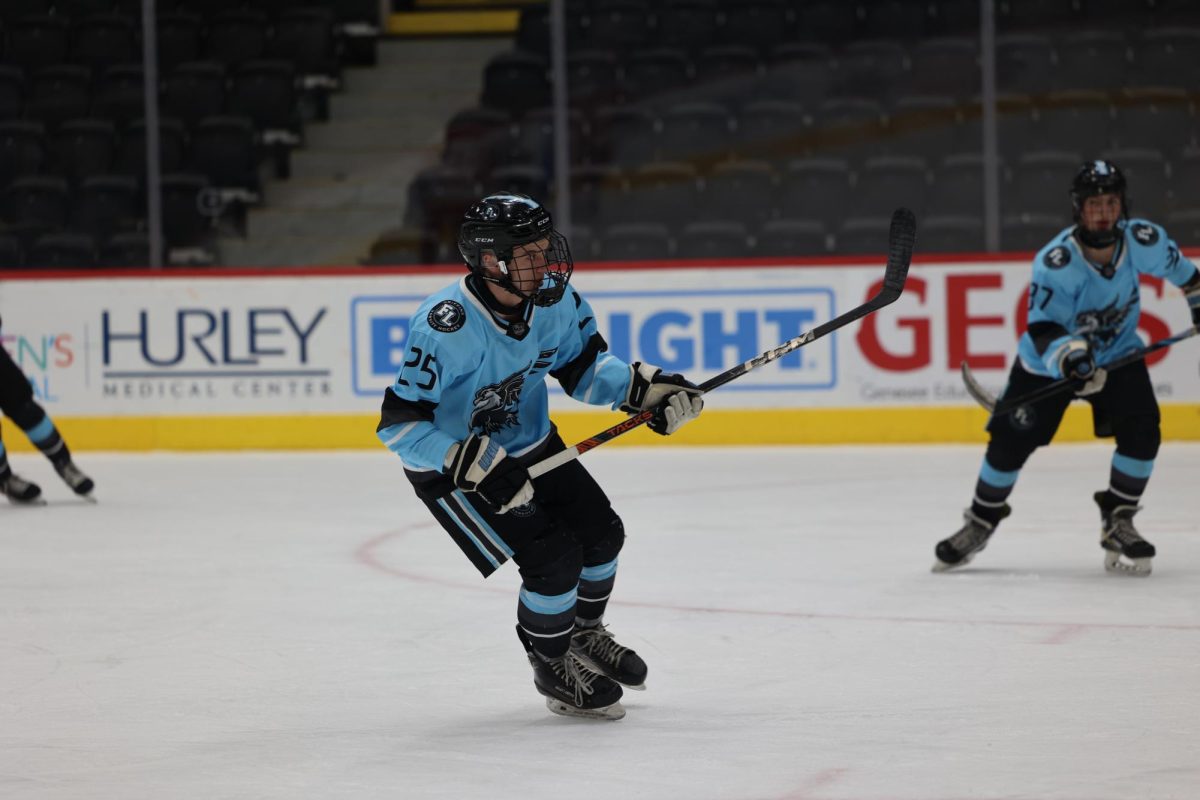 Looking down the ice, junior Mason Wright skates toward the goal. On Feb. 4, the Griffins played Anchor Bay HS and lost 2-4.