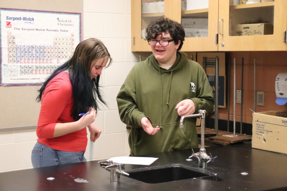 Laughing, sophomores Emma Scott and Gage Ogle finish the lab. On Feb. 24, science teacher Jason Kasak has a free fall lab in his classroom.