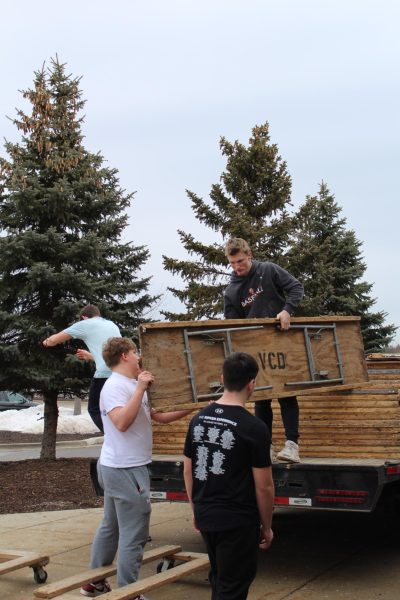 Lifting, junior Noah Sheil gives his teammate Zach Bujak a table. On feb 28 the fenton football teams helped prepare for the Expo.