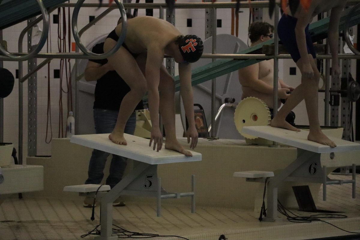 Waiting, junior Nate Hartzell prepares to dive in. On Dec 16, the FHS boys swim team competed at counties. 