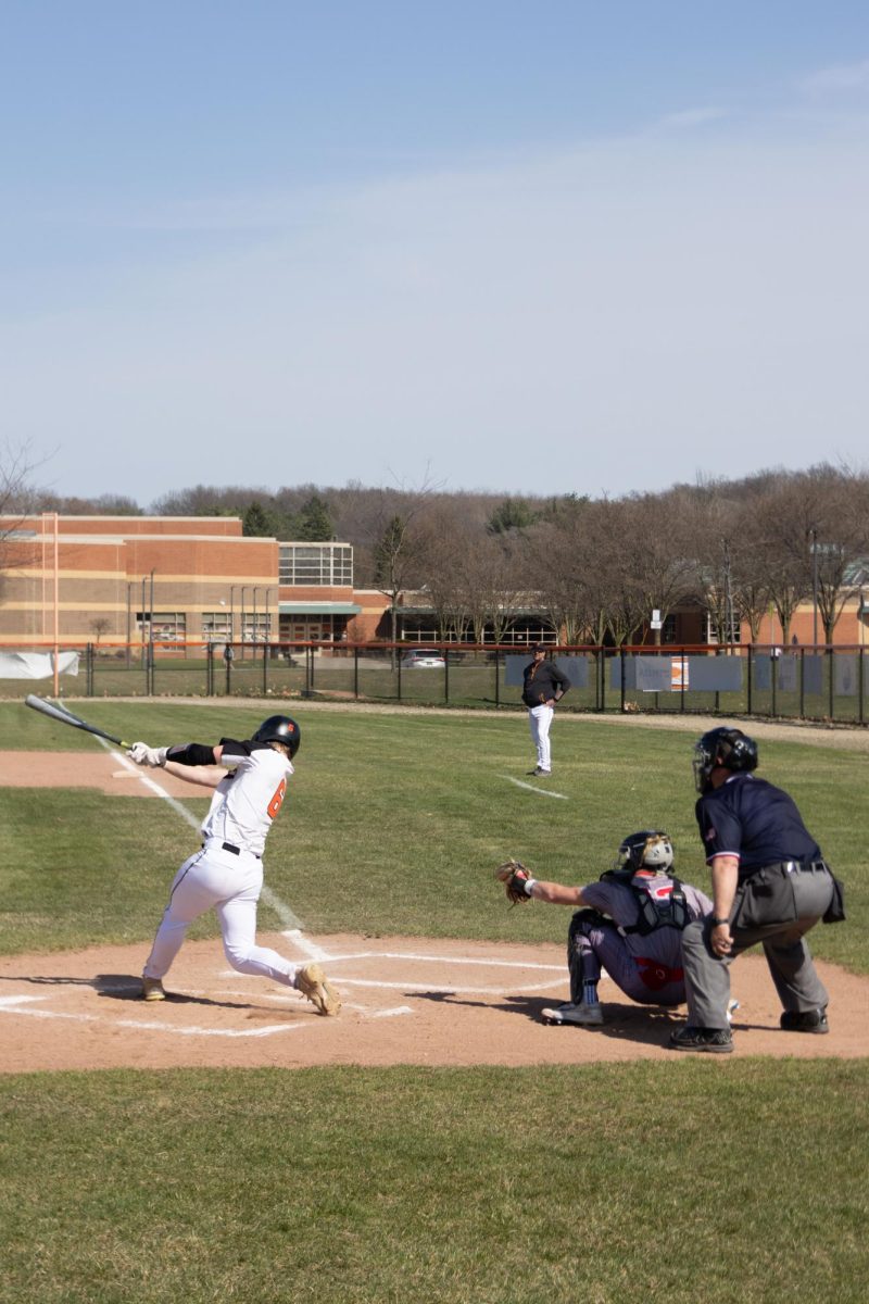 Swinging, junior Luke Dotson hits the baseball. On Apr. 14, Fenton had a doubleheader against Holly High School, winning one game. 
