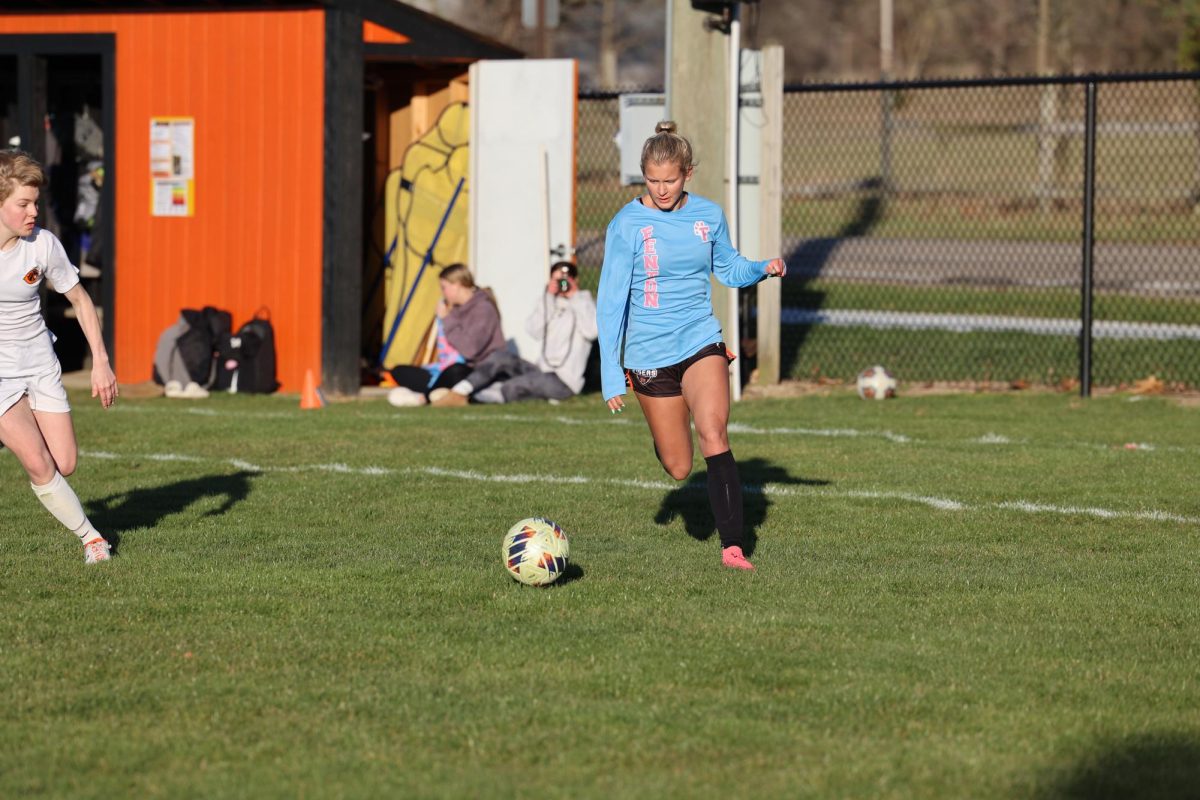 Looking at the ball, junior Lauren Chapple runs toward the goal. On April. 16, the Fenton girls varsity soccer team played Clio and won 5-0.