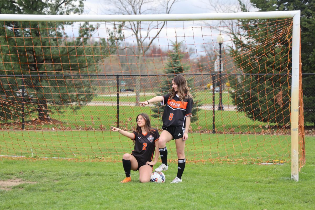 Posing, sophomore Anna Koscielniak and sophomore Peyton kelso smile at the camera. On April 21, the JV and Varsity girls soccer had team picture day.