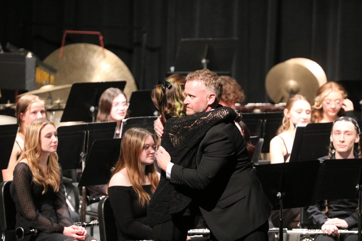 Celebrating, Patrick Conaton and junior Reese Kildee hug one another. On April. 16, the band held a concert in the auditorium. 