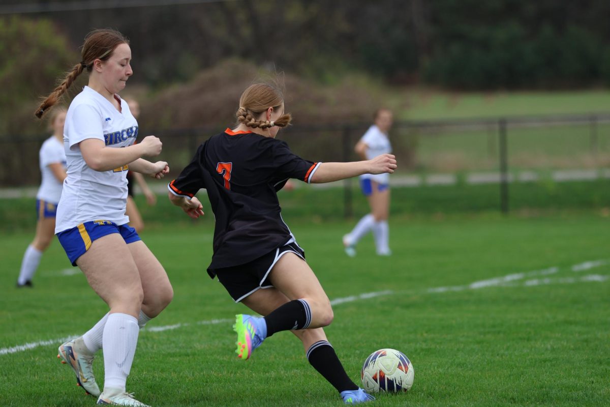 Defending, sophomore Lilly Reynolds kicks the ball. On April 23, the JV Girls Soccer team played against Birch Run.