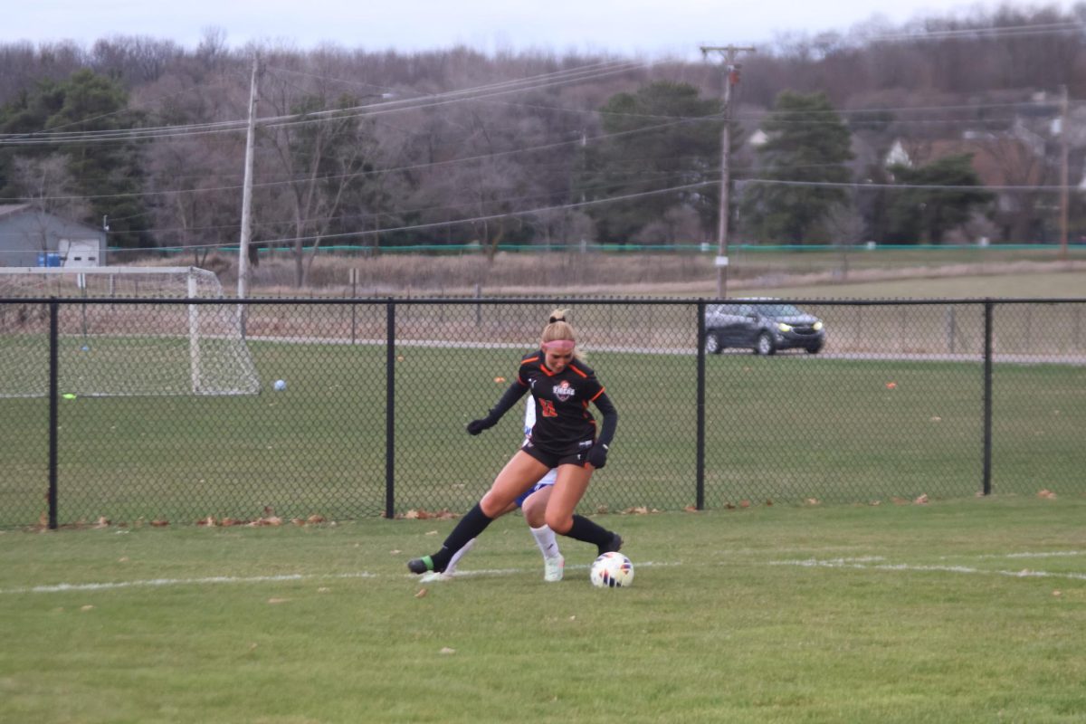 Blocking, senior Brielle Roberts defends the ball from her opponent. On April. 15, the Fenton girls varsity girls soccer team played Genesee Christian and won 4-0.