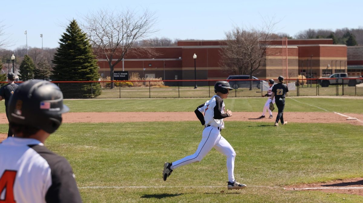 Running, junior Nick Brown heads toward home plate, scoring for his team. On Apr. 12, Fenton competed against Clarkston in a doubleheader, taking the win for the first game. 