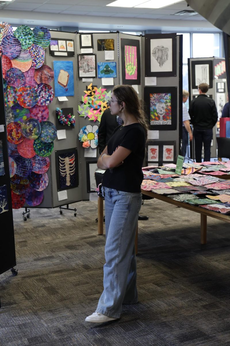 Admiring the art, senior Ariana Papcun attends the Fenton High school art show. On Apr. 17, the FHS art students had their work displayed for family and friends to see. 